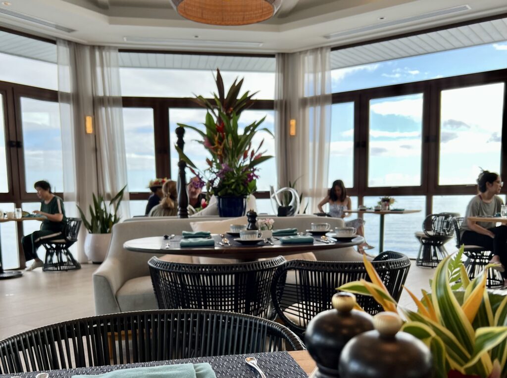 a room with tables and chairs and a large window