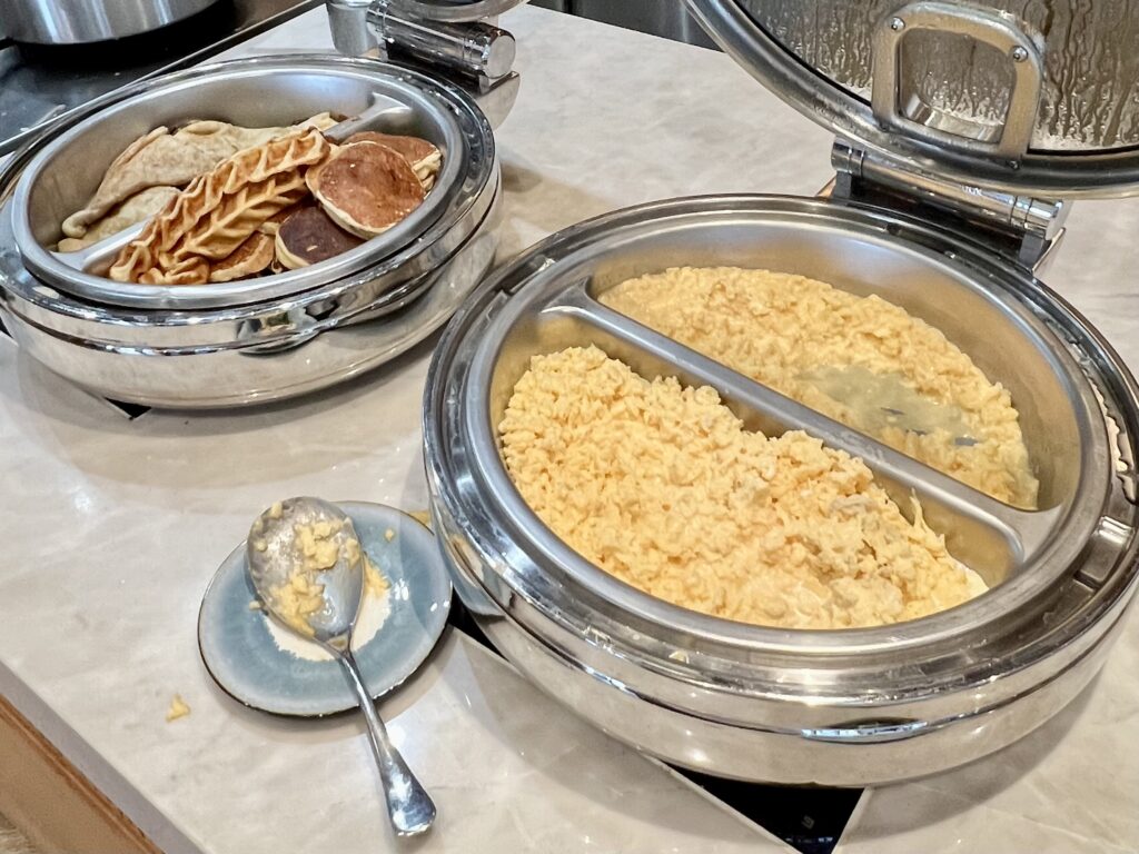 a breakfast buffet with pancakes and scrambled eggs