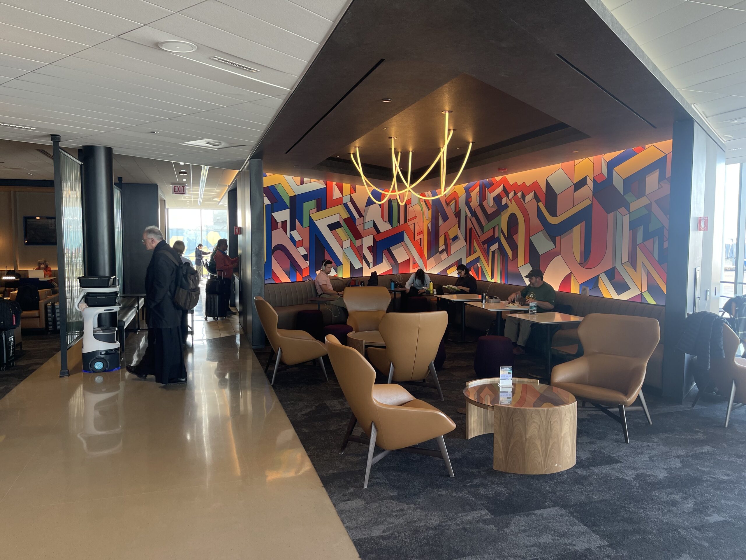 United Club Chicago ORD a room with a colorful wall and chairs