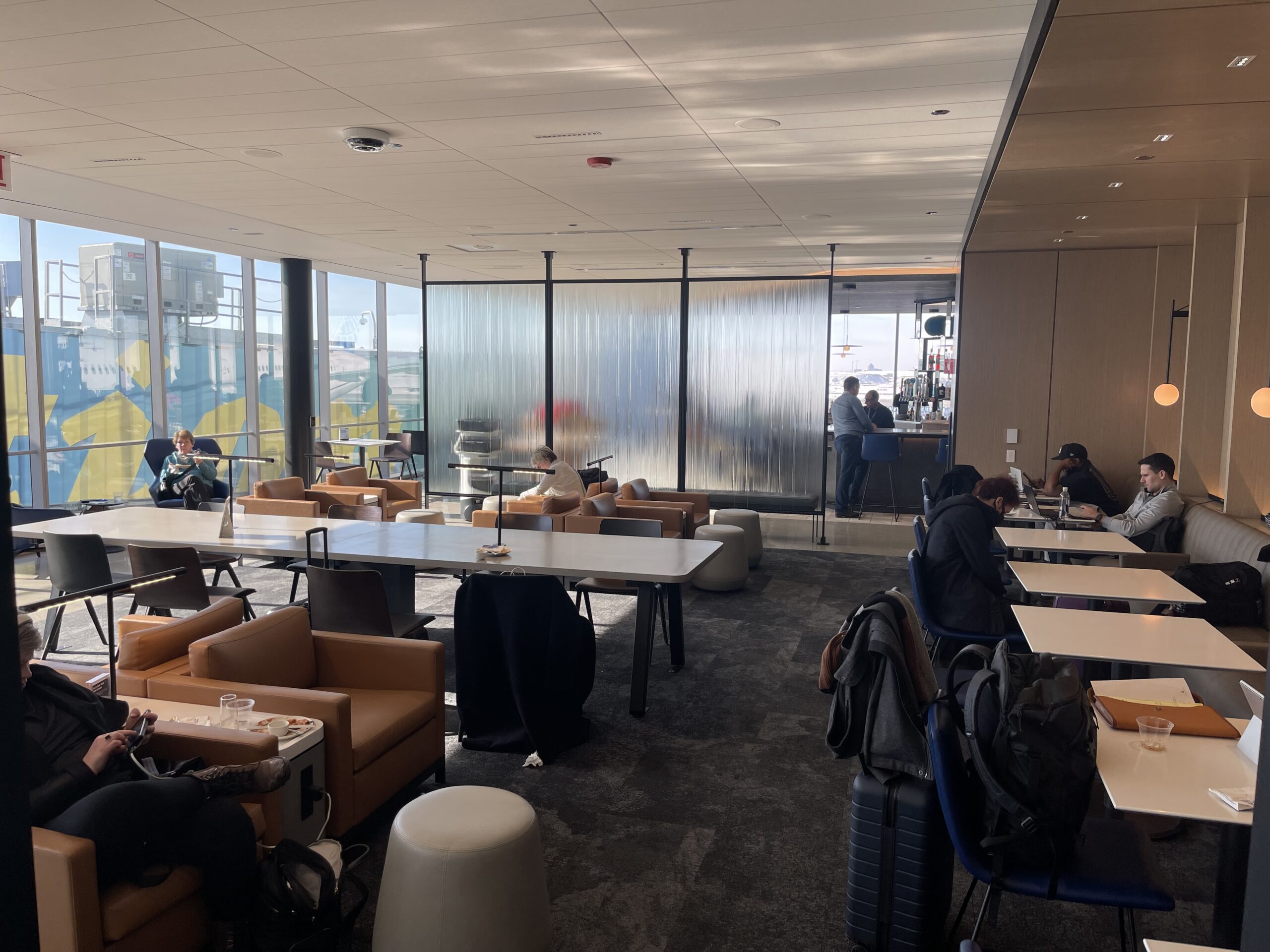 United Club Chicago ORD a room with tables and chairs and people in it