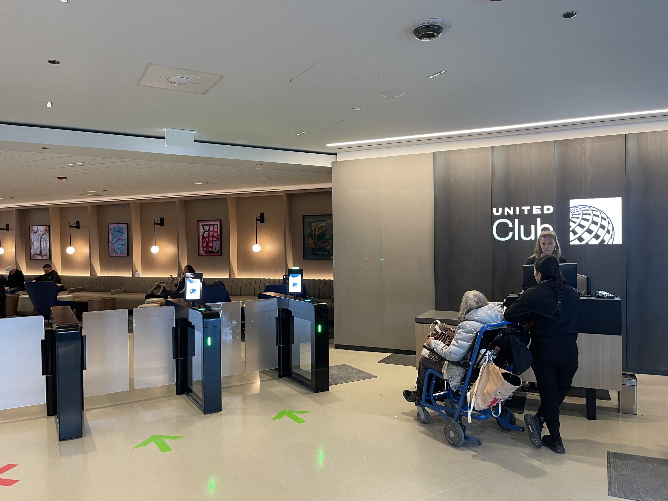 United Club Chicago ORD a group of people standing in front of a check-in counter