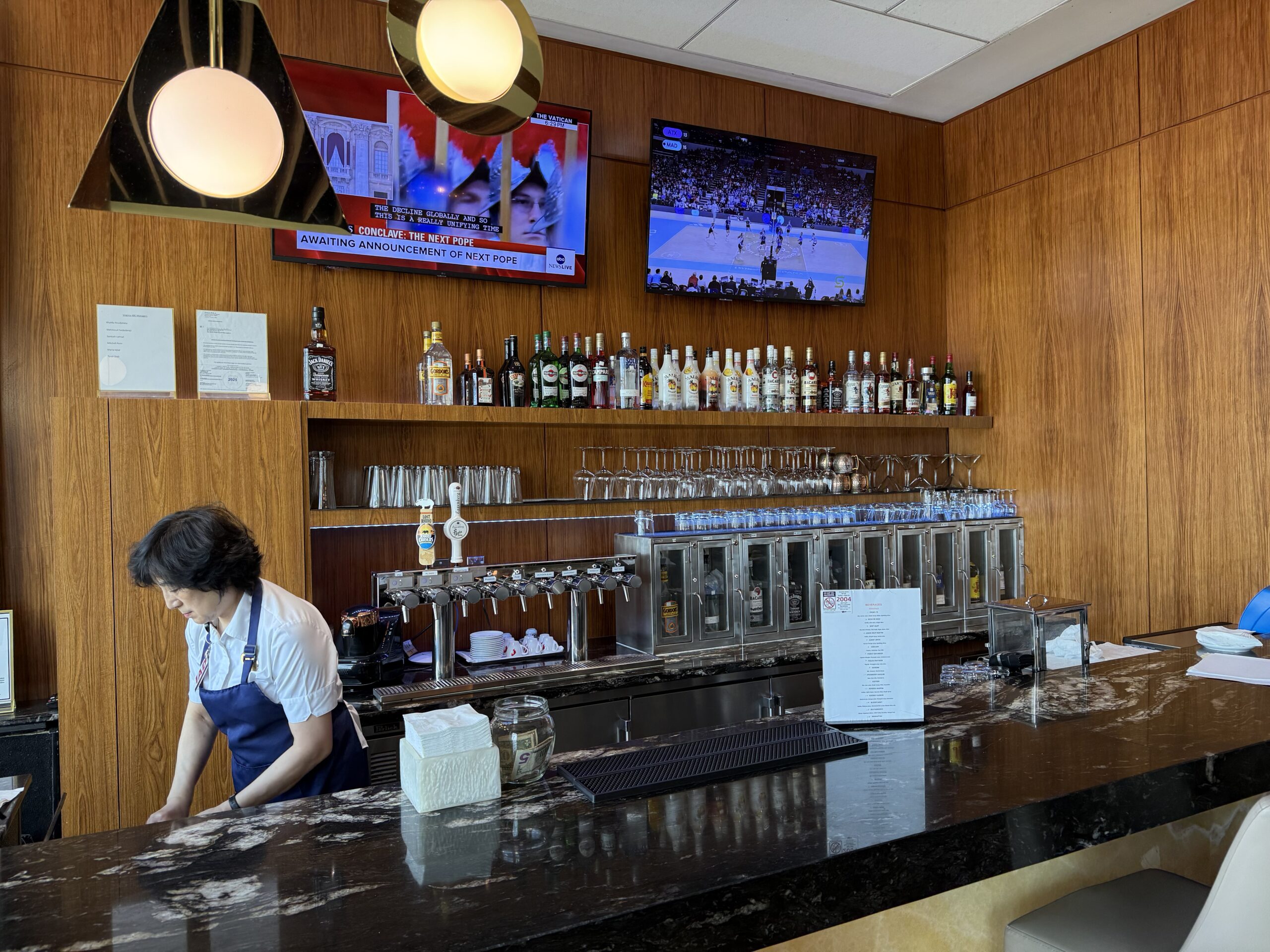 Turkish Airlines Lounge Washington a woman behind a counter in a bar
