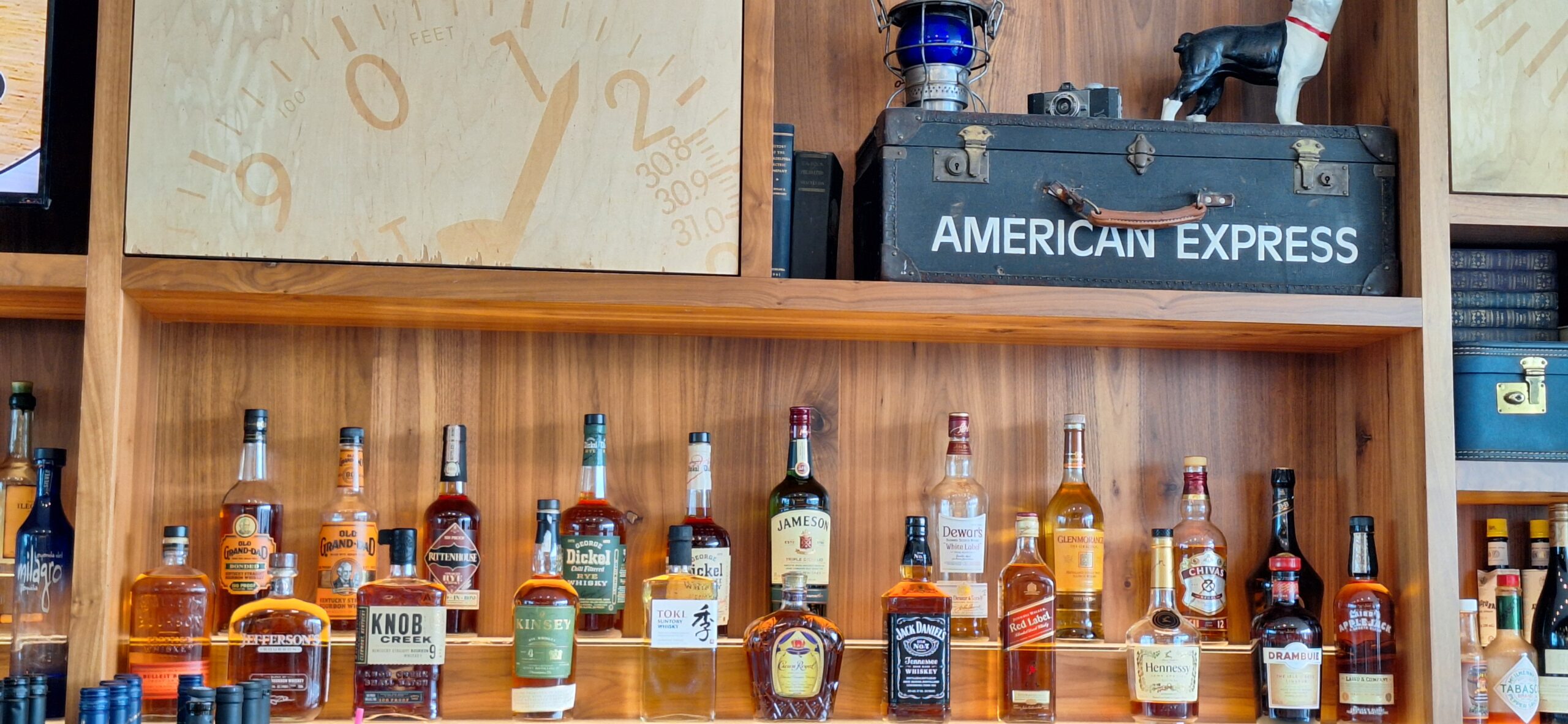 Centurion Lounge Philadelphia a shelf with bottles of alcohol