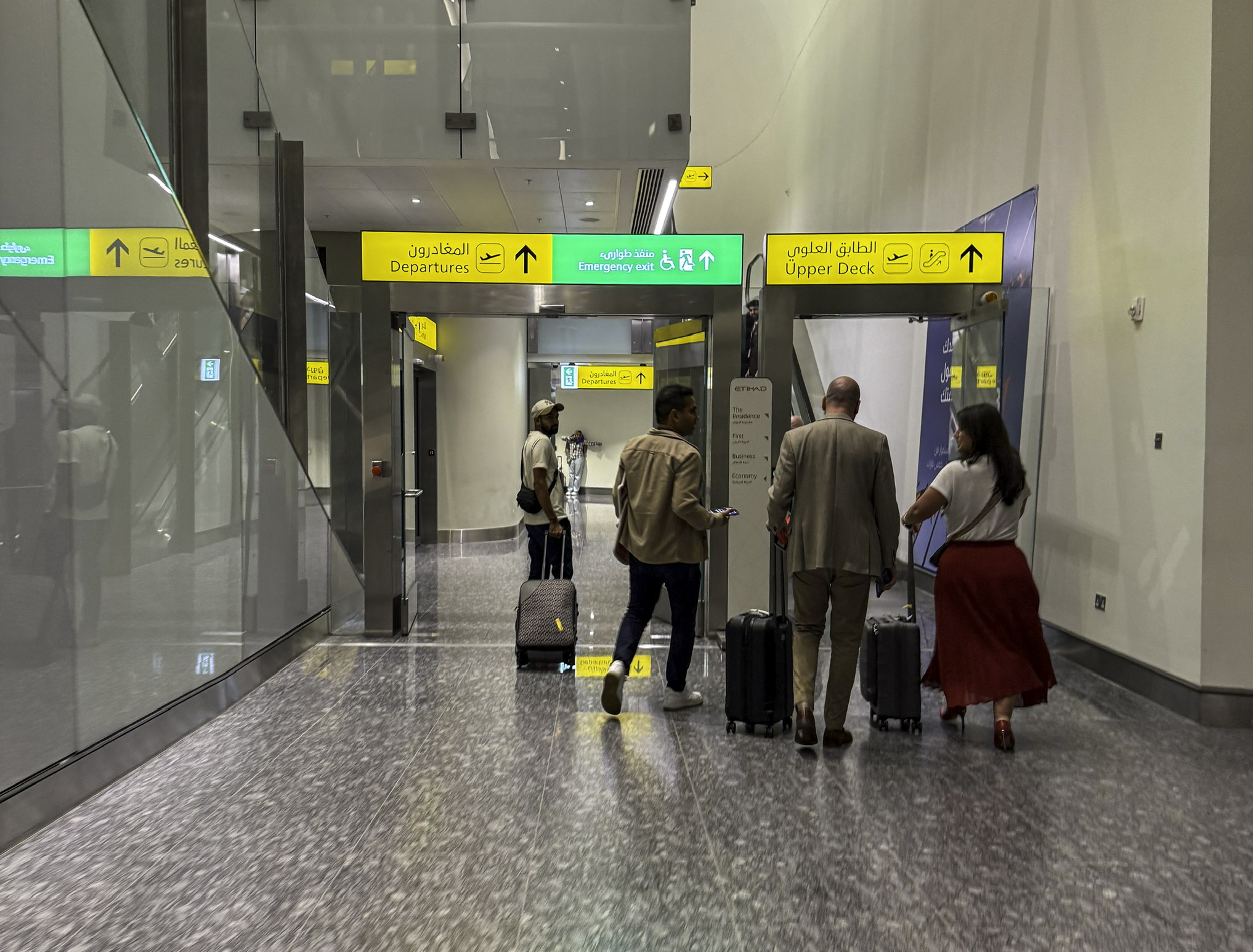 a group of people with luggage in a hallway