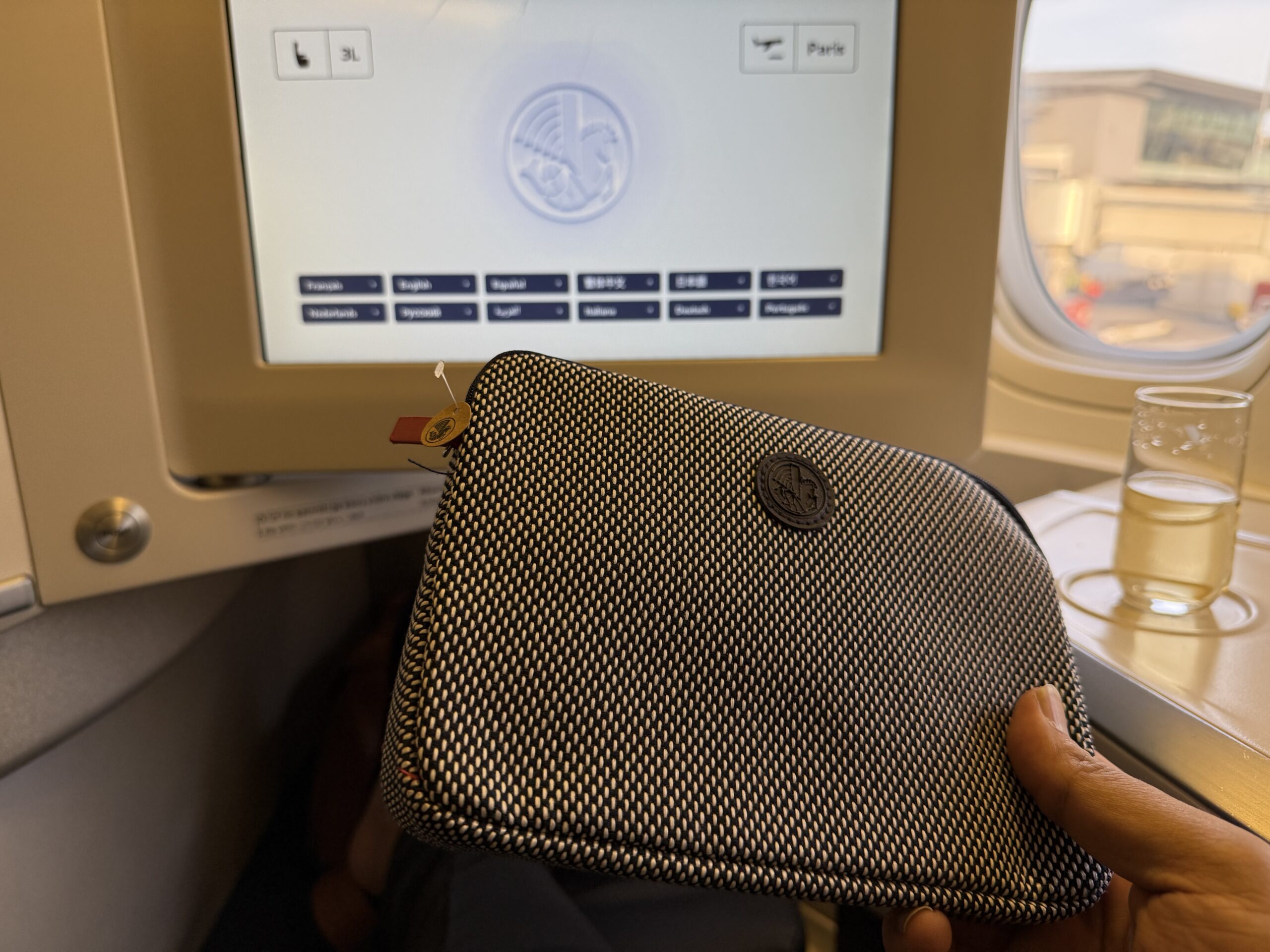 Air France Ottawa to Paris a hand holding a purse in front of a computer screen