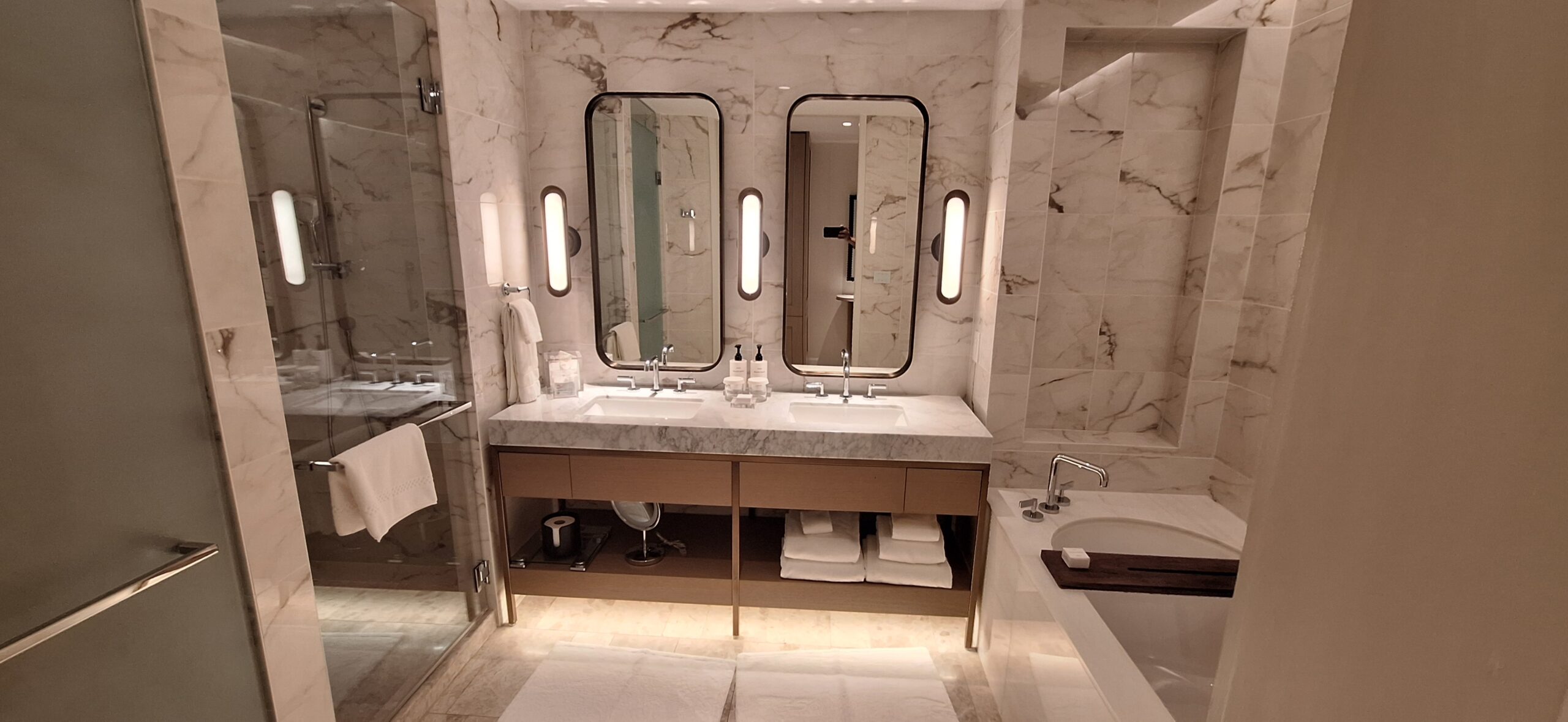 Conrad Nashville Review a bathroom with marble walls and sinks