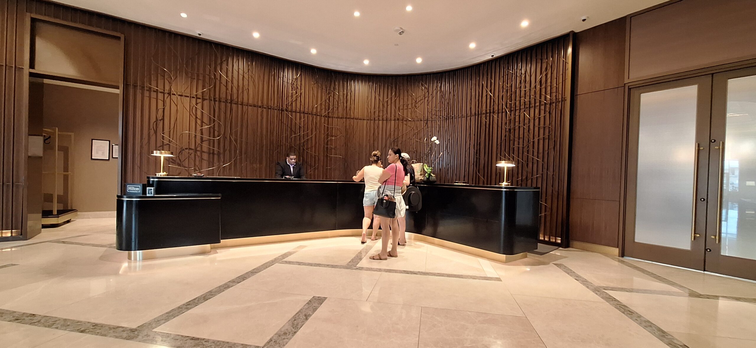 Conrad Nashville Review a group of people standing in front of a reception desk