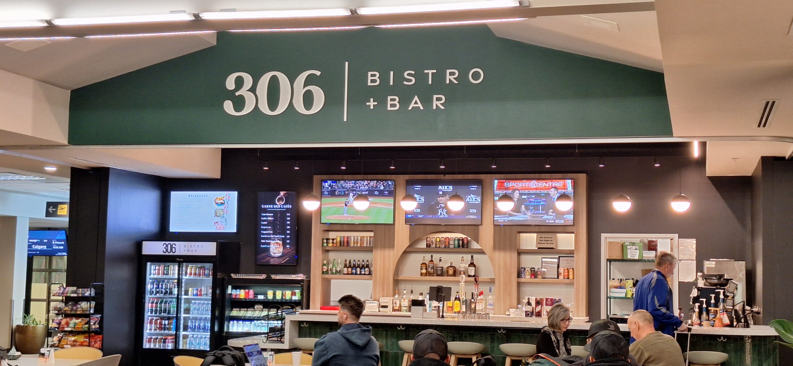 a bar with a sign and people sitting at tables