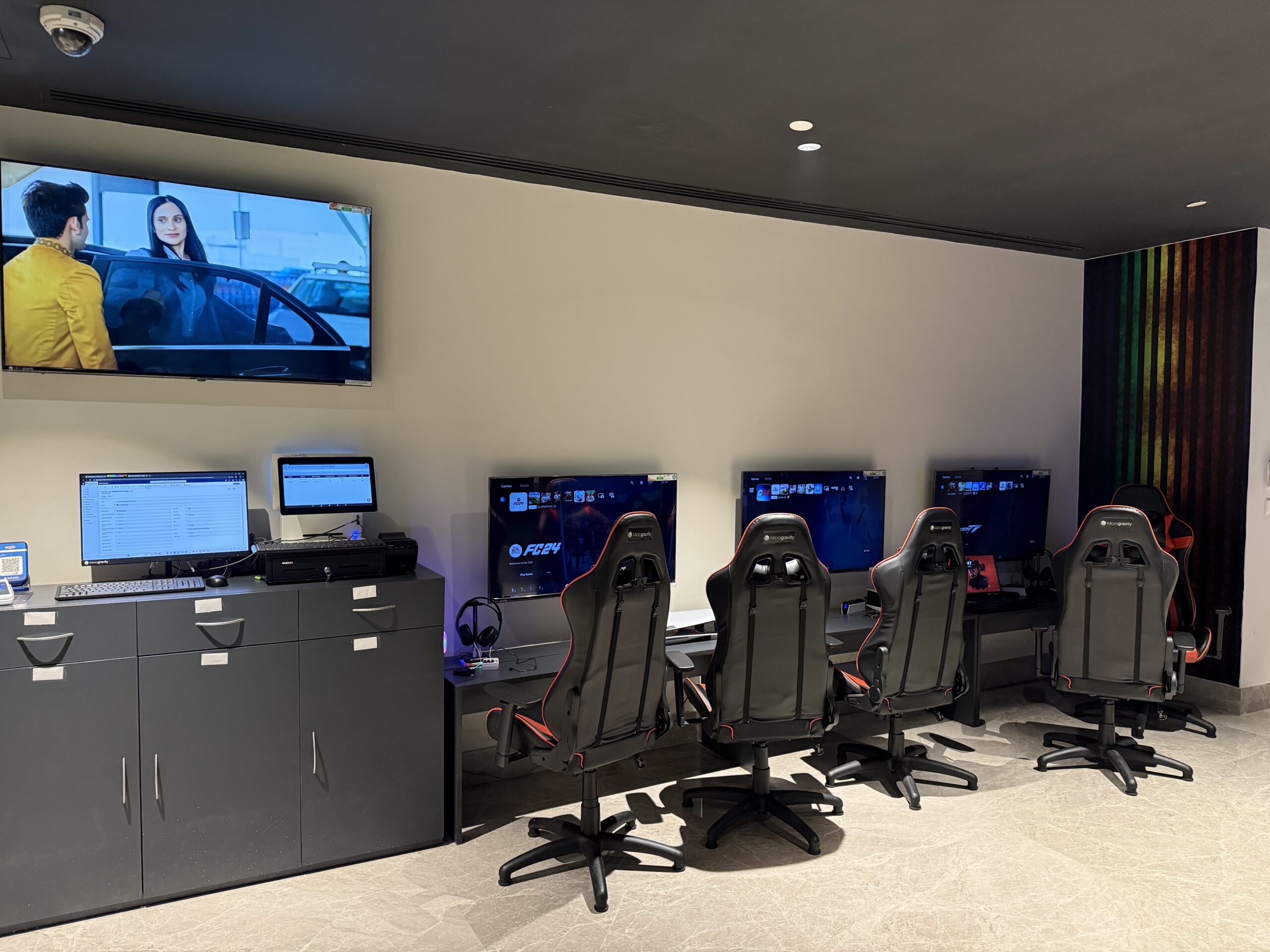 a room with several computers and a television on the wall