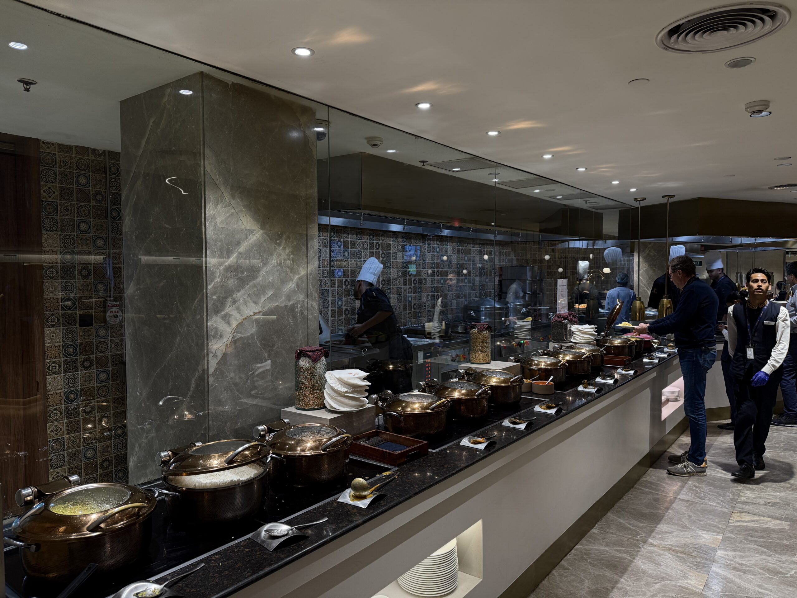 a group of people standing in a room with food on the counter