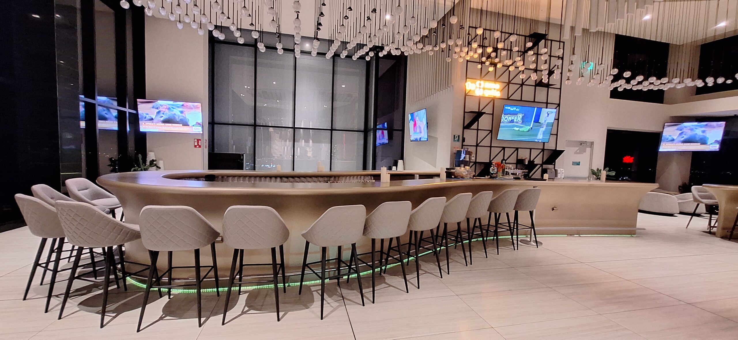 a bar with chairs in front of a television