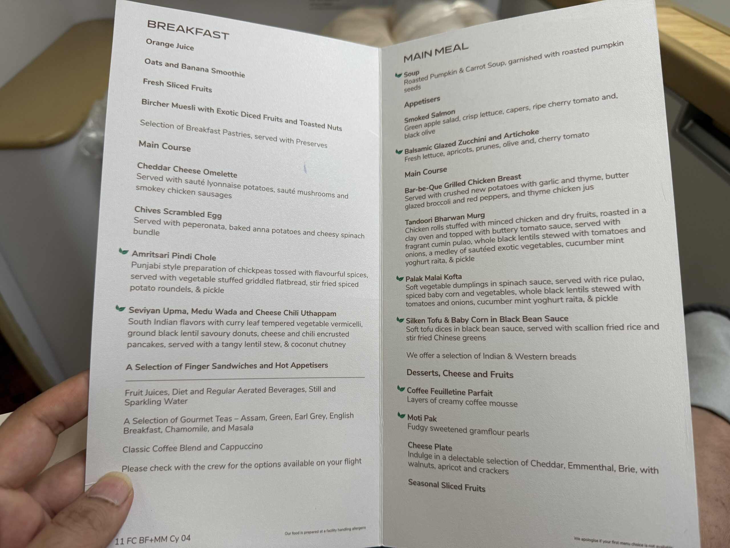 Air India First Class a hand holding a menu