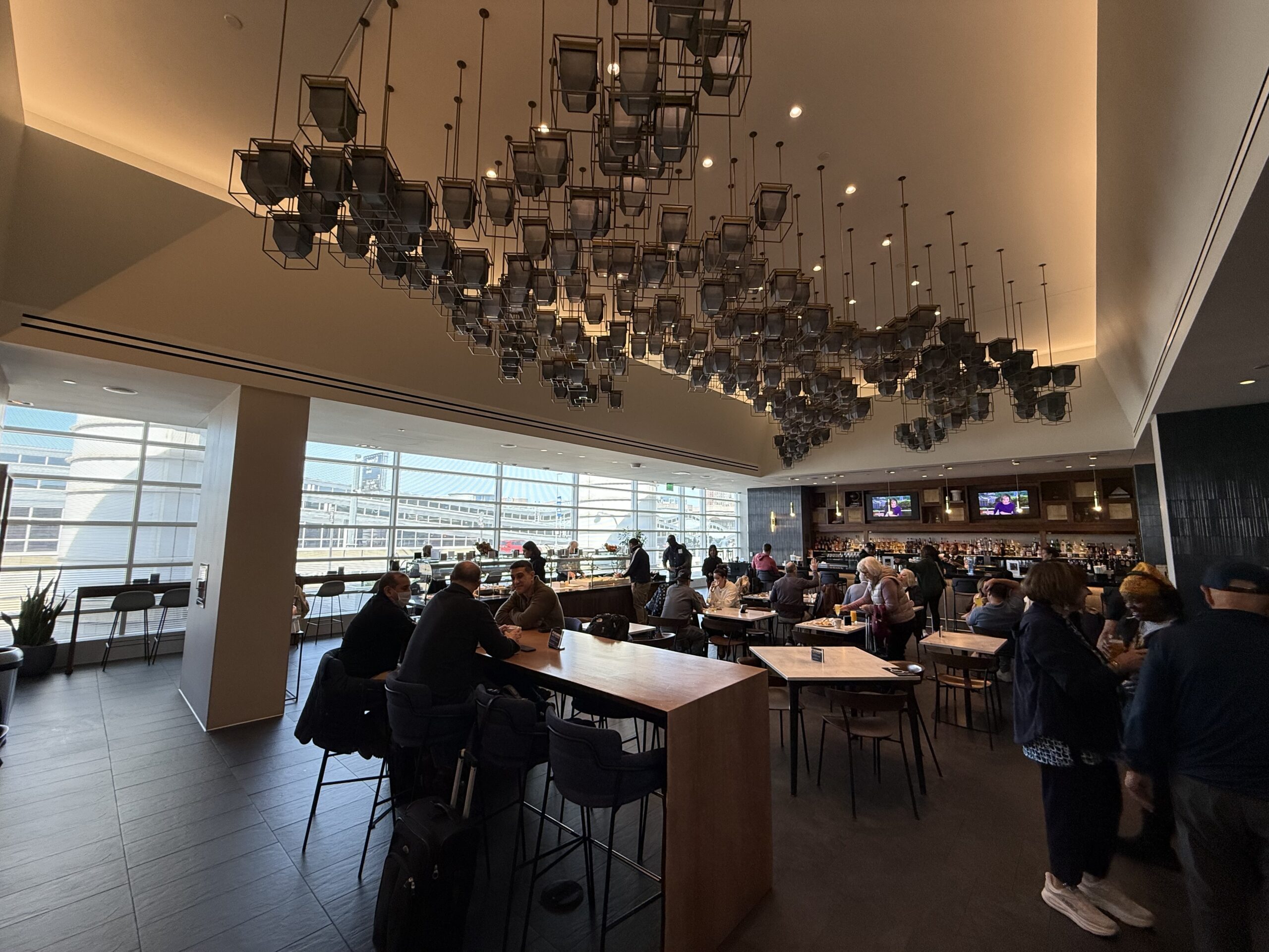 a group of people sitting at tables in a room with windows