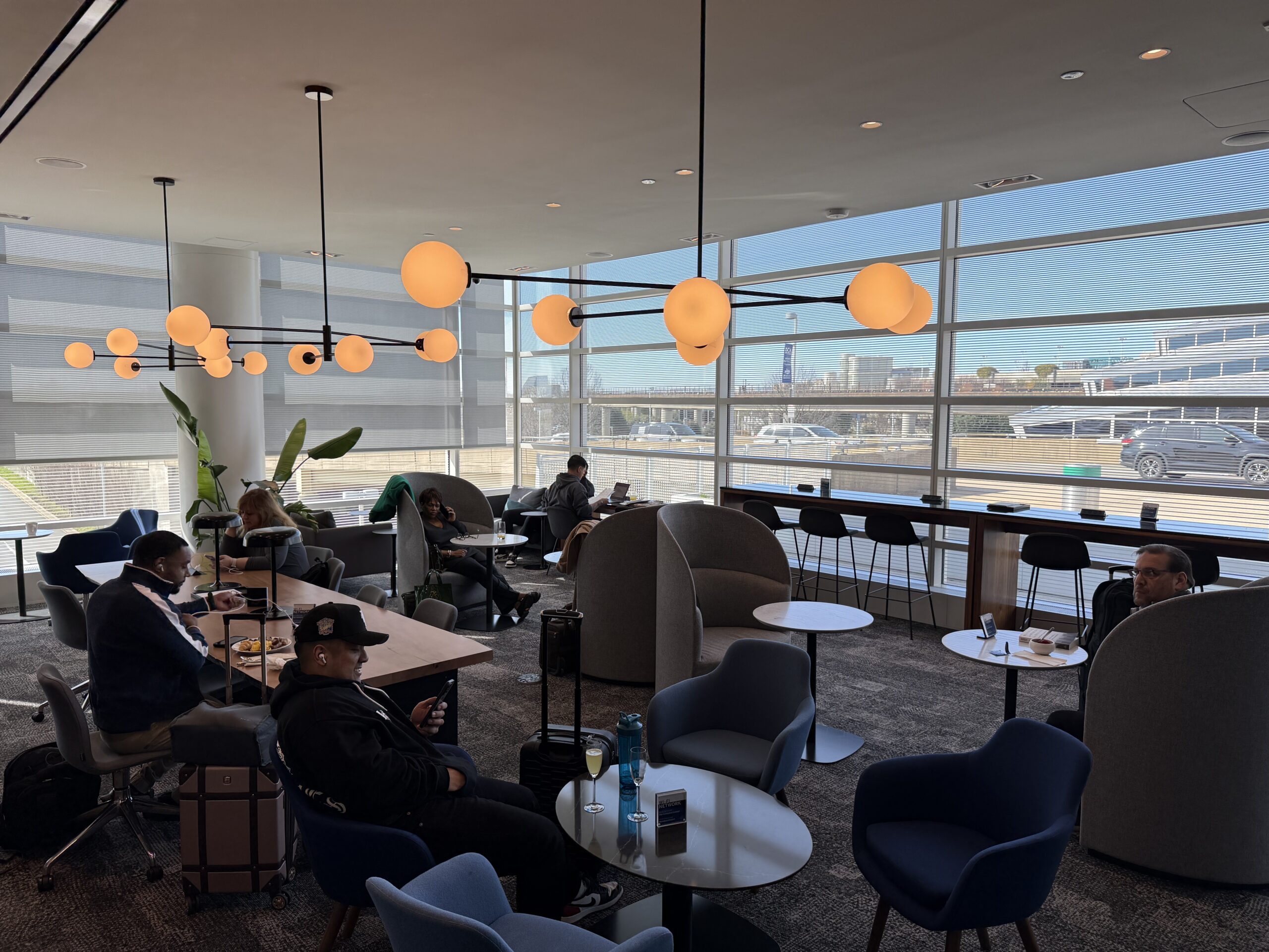 a group of people sitting at tables in a room with large windows