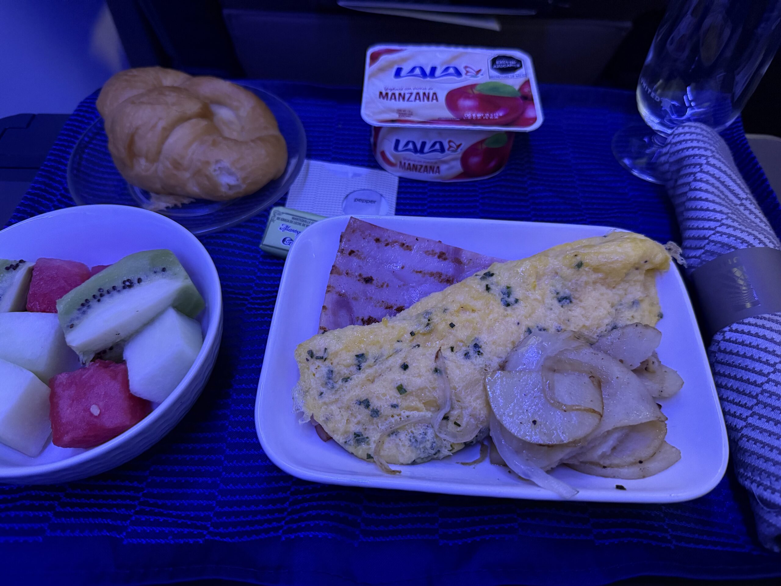 United First 737 Max a plate of food and a croissant on a table