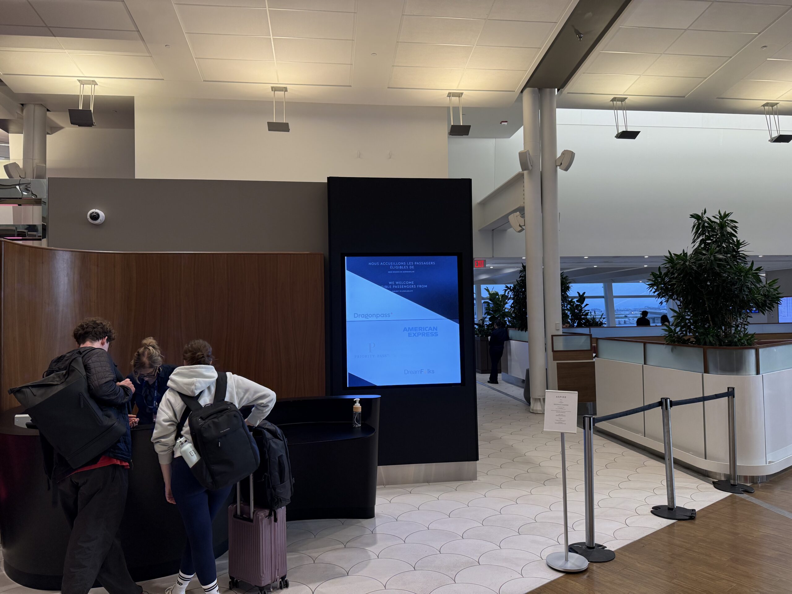people standing in a lobby with a screen