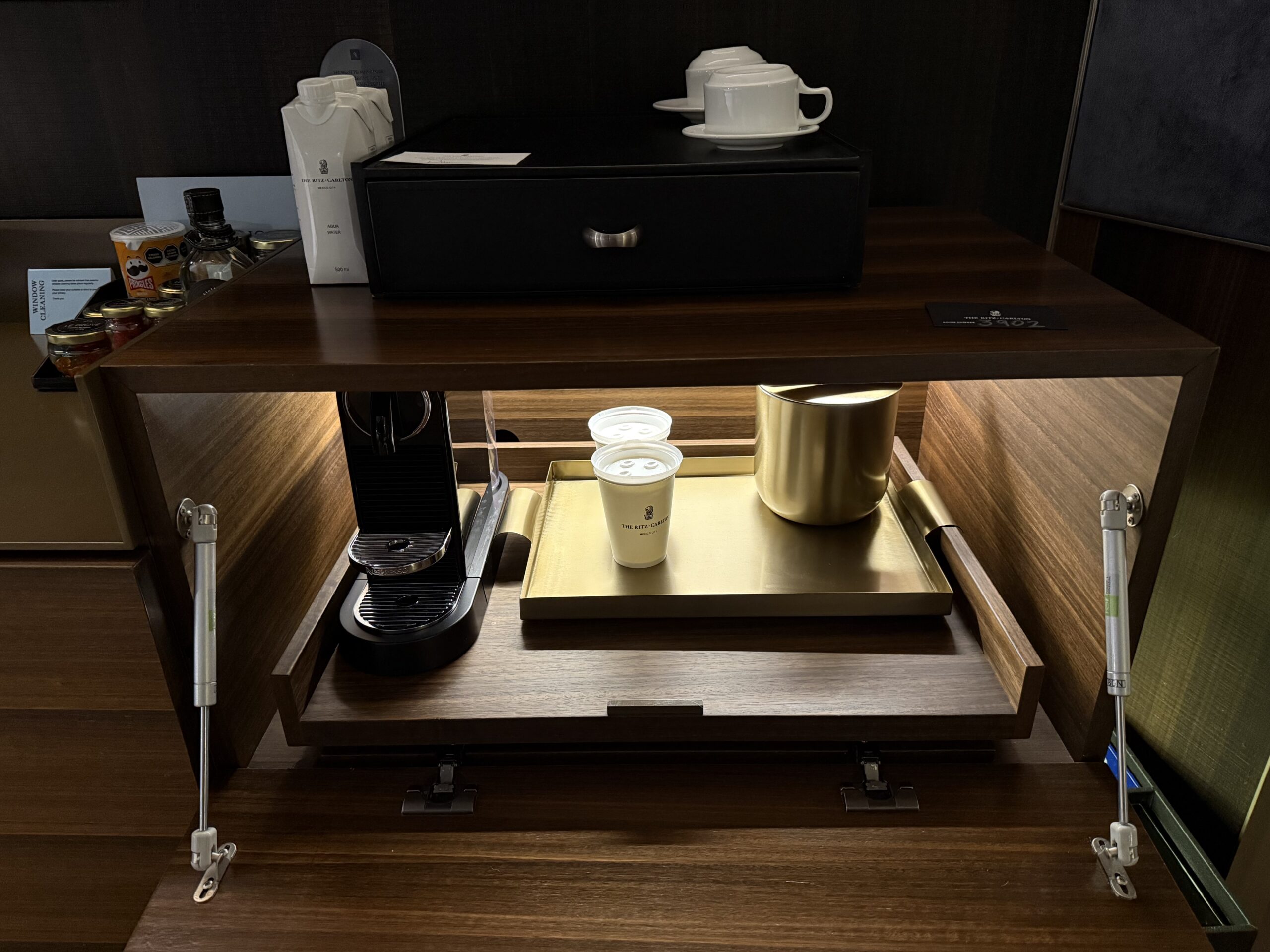 a coffee machine and cups on a shelf
