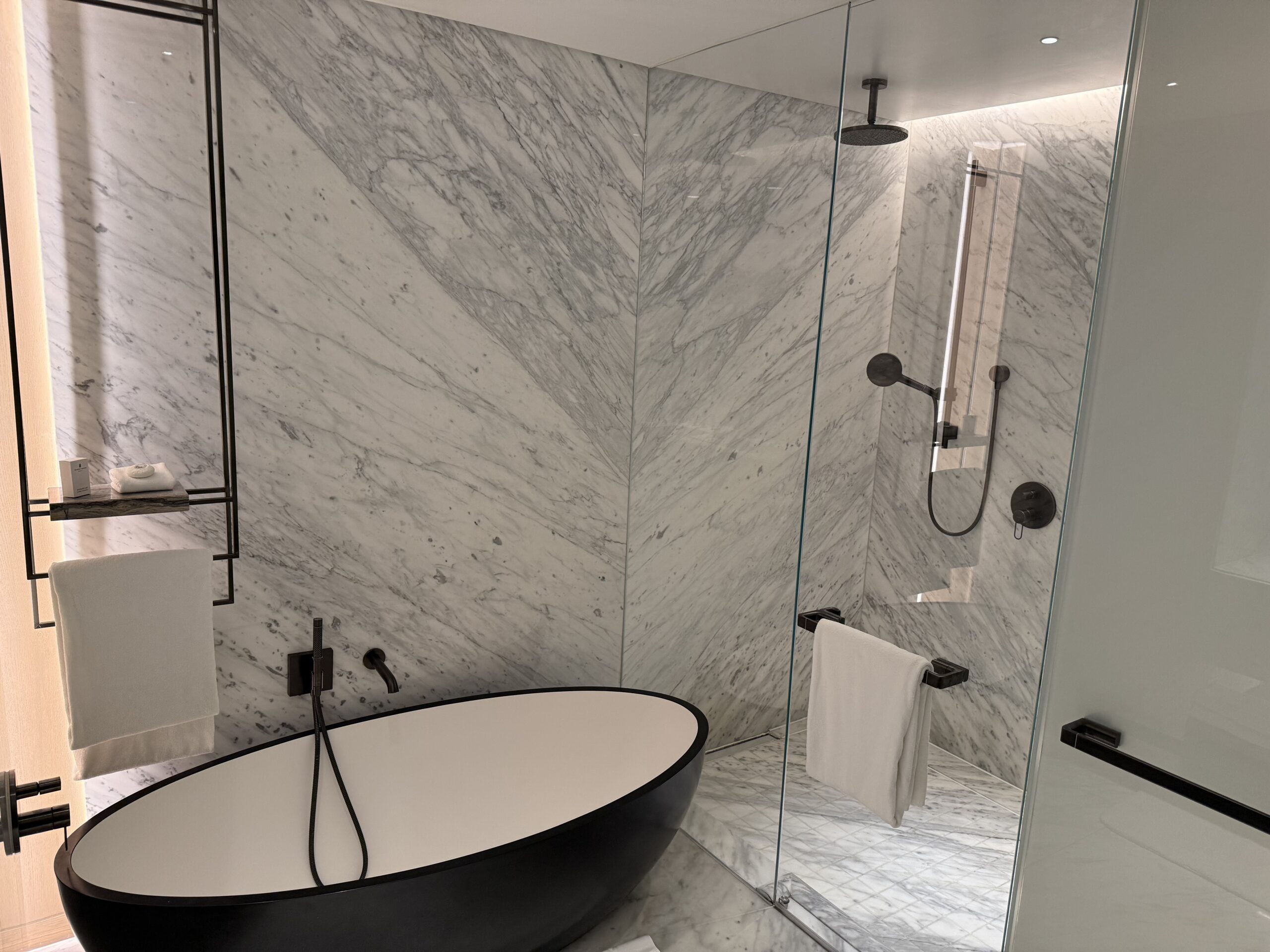 a bathroom with a black oval tub and a shower