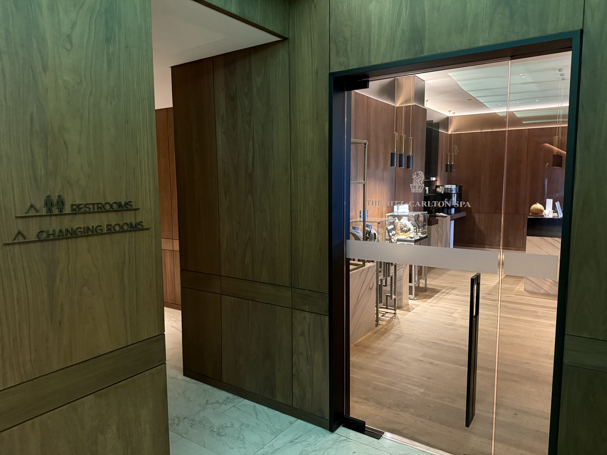 a glass door with a wood wall and a wood floor