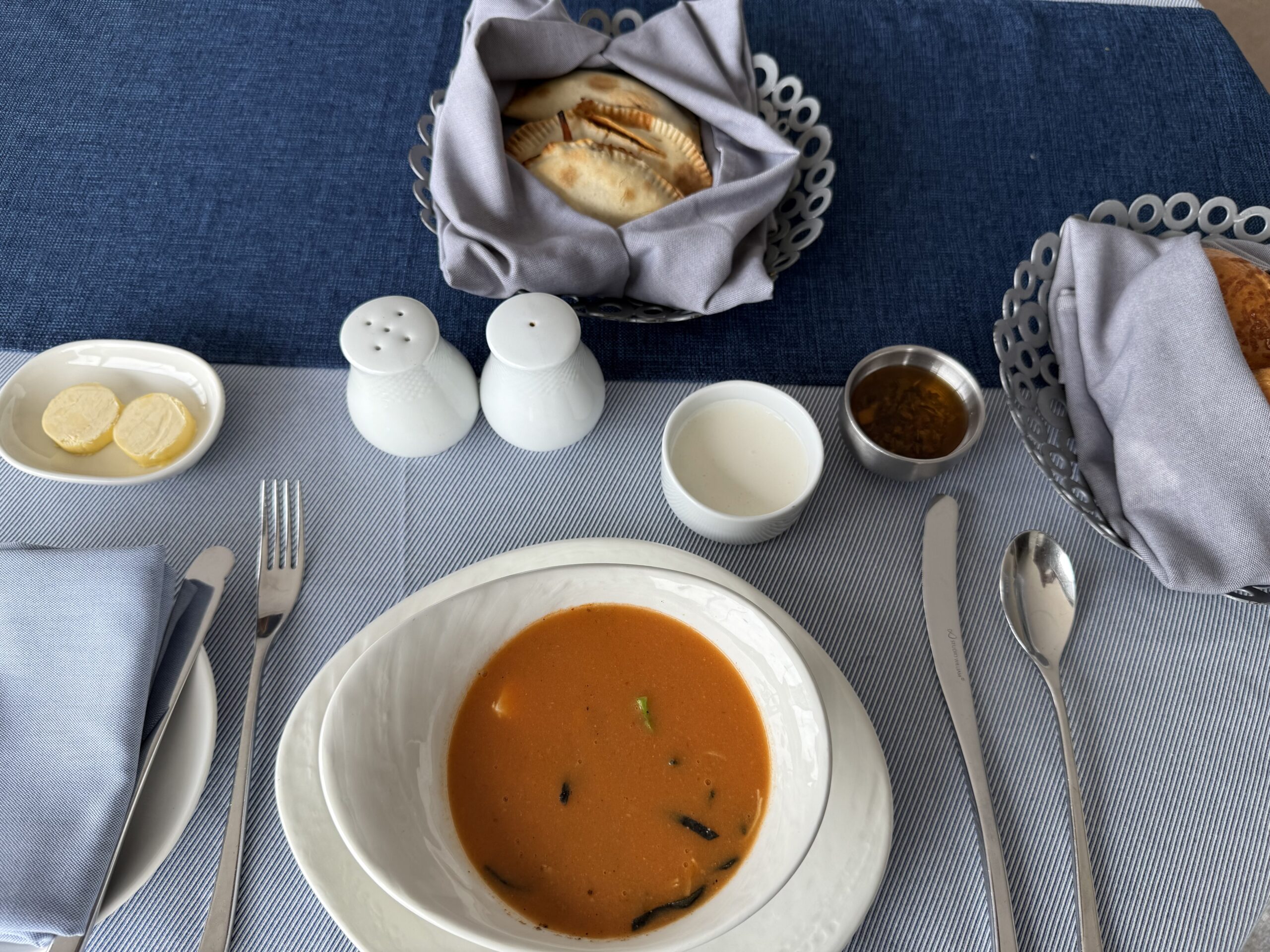 a bowl of soup and salt and pepper shakers on a table