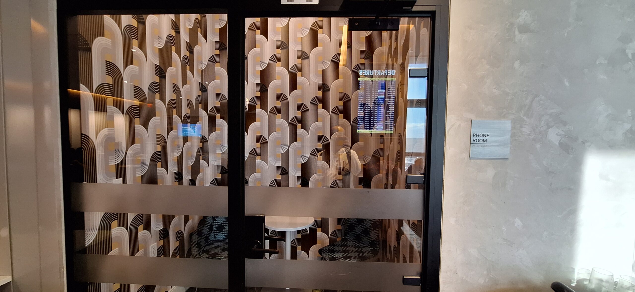 Centurion Lounge Las Vegas a glass door with a patterned curtain