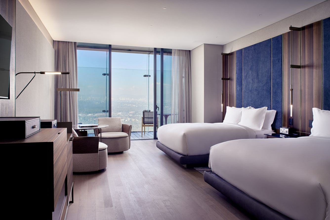 a room with two beds and a large window