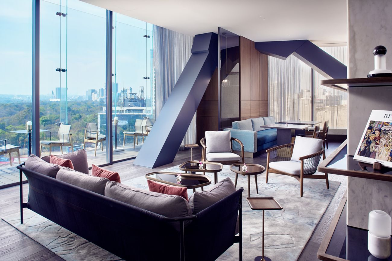 a room with a large window and a couch and chairs