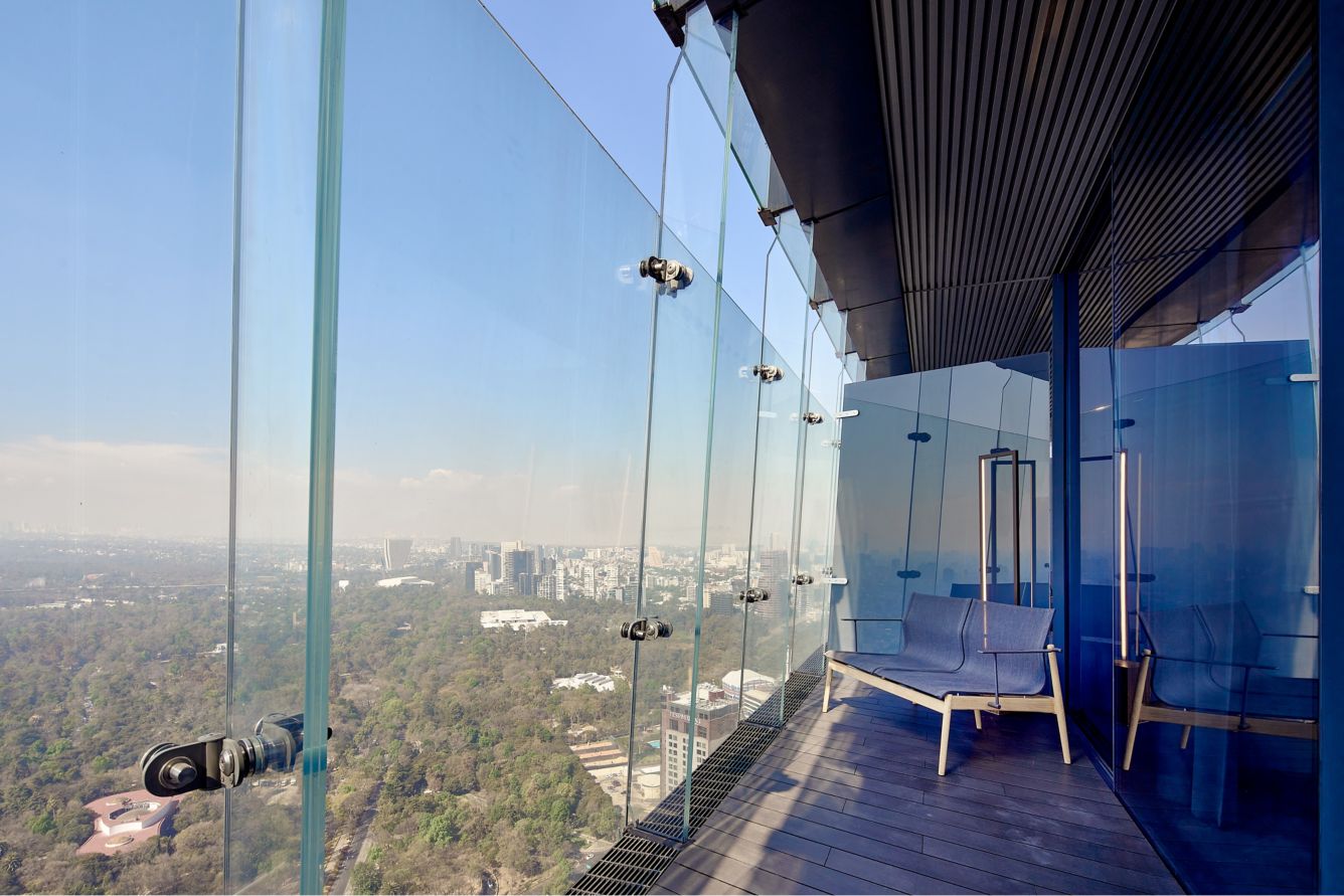 a bench on a balcony overlooking a city