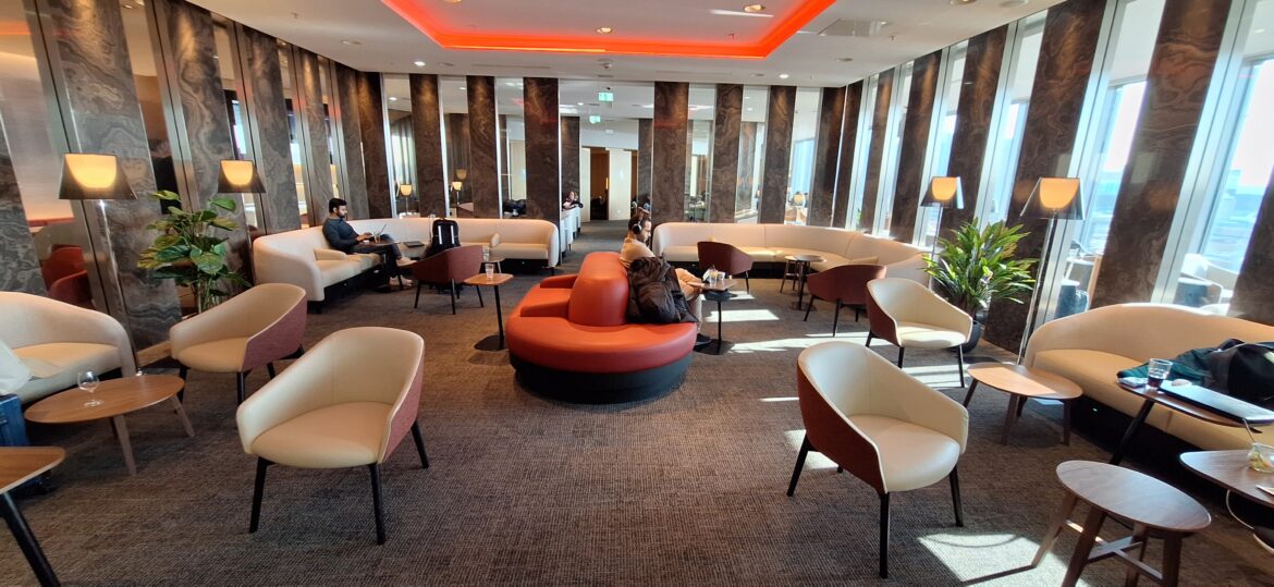 a room with a red round couch and chairs