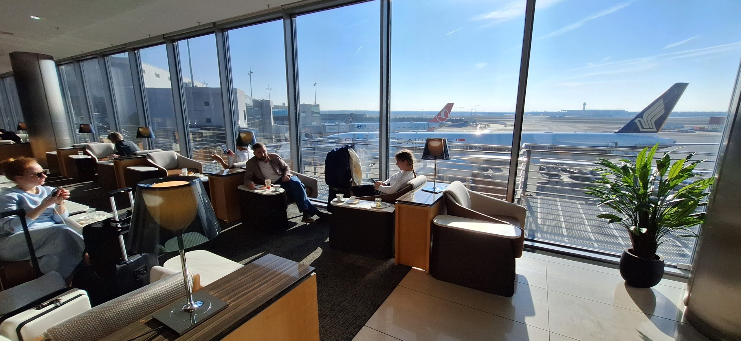 people sitting in a lounge area with a large window