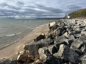 a rocky beach with a person walking on it