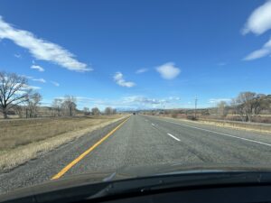 a road with trees and blue sky