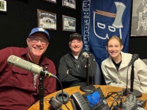 a group of people sitting at a table with microphones