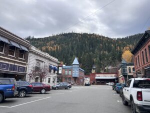 a street with cars parked in front of a mountain