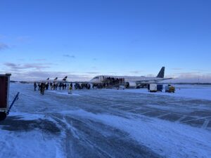 a group of people standing next to an airplane