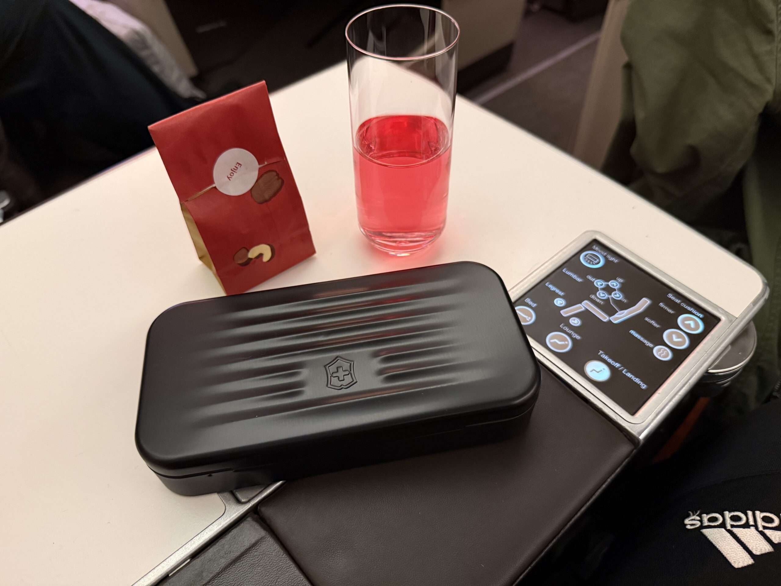 Swiss Business Class A330 a glass of liquid and a rectangular object on a table