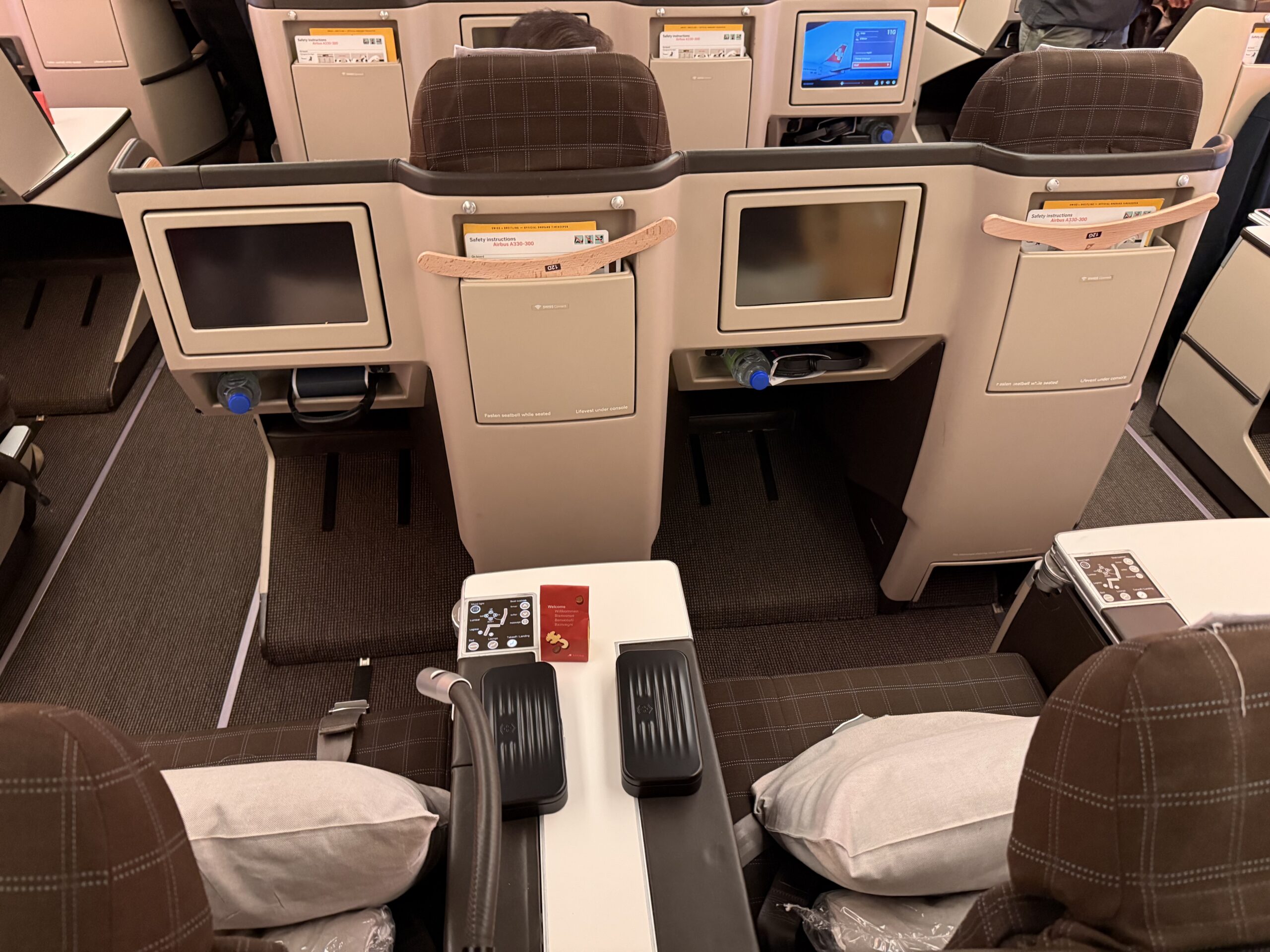 Swiss Business Class A330 a seat with a table and chairs in the back