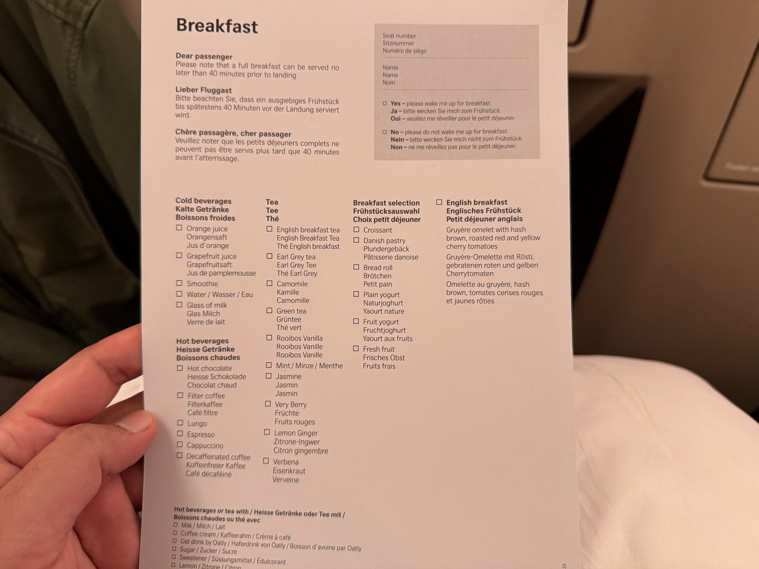 Swiss Business Class A330 a hand holding a piece of paper