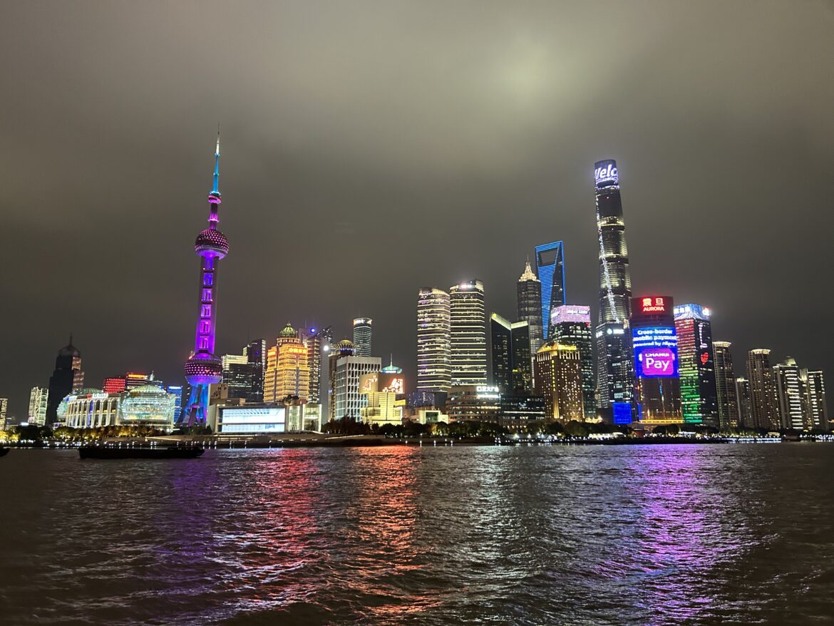 a city skyline with lights and a body of water