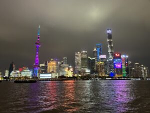 a city skyline with lights and a body of water