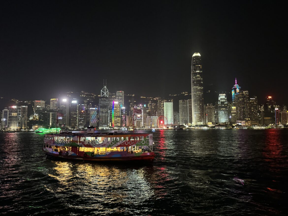 a boat on the water with city lights at night