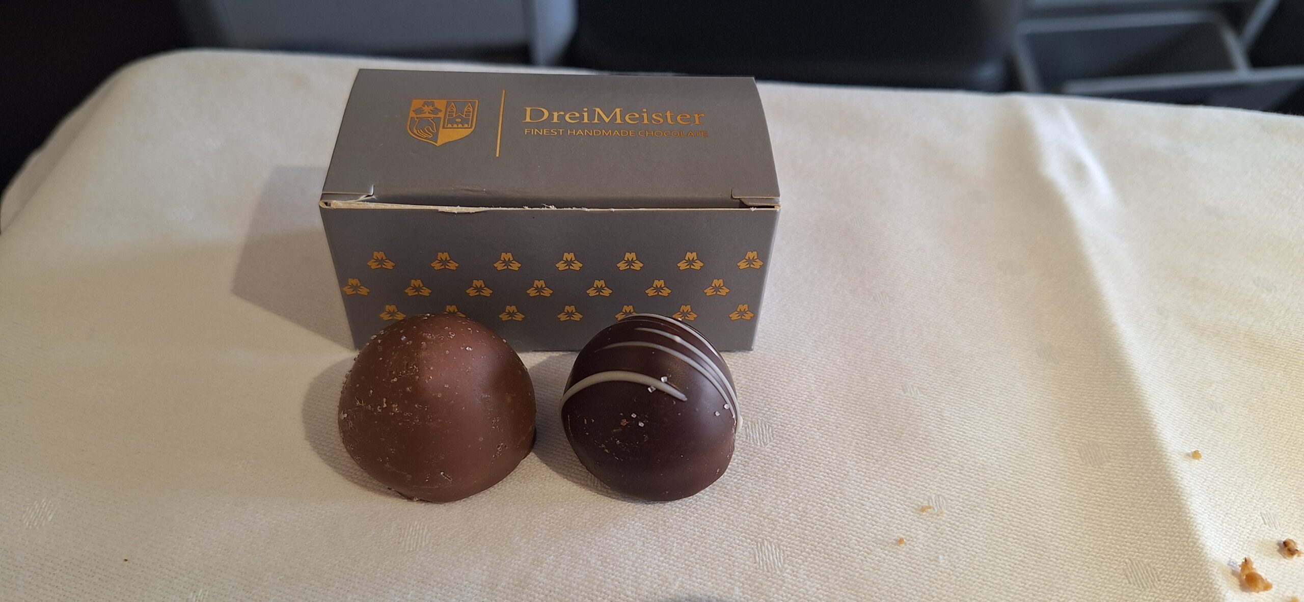 two chocolates next to a box