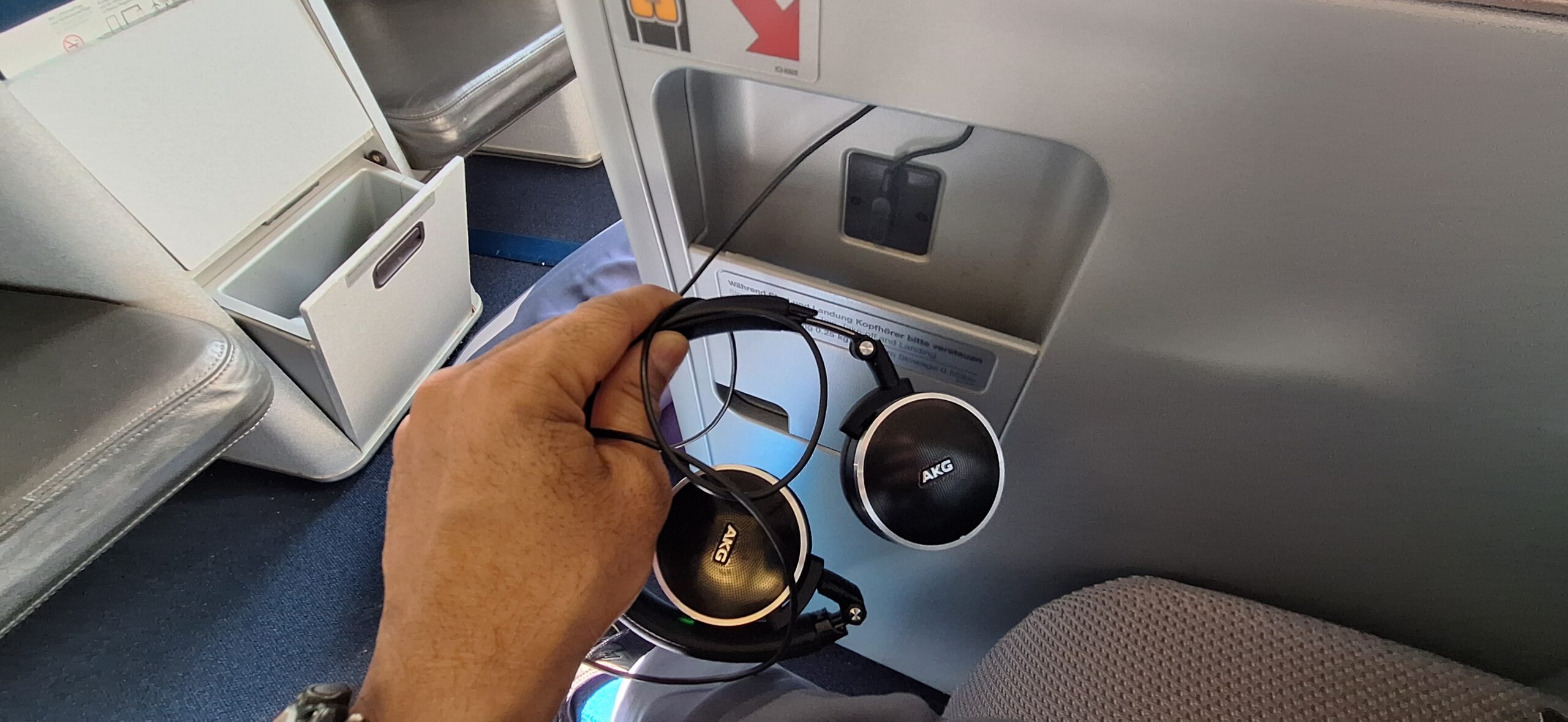 a hand holding a pair of headphones