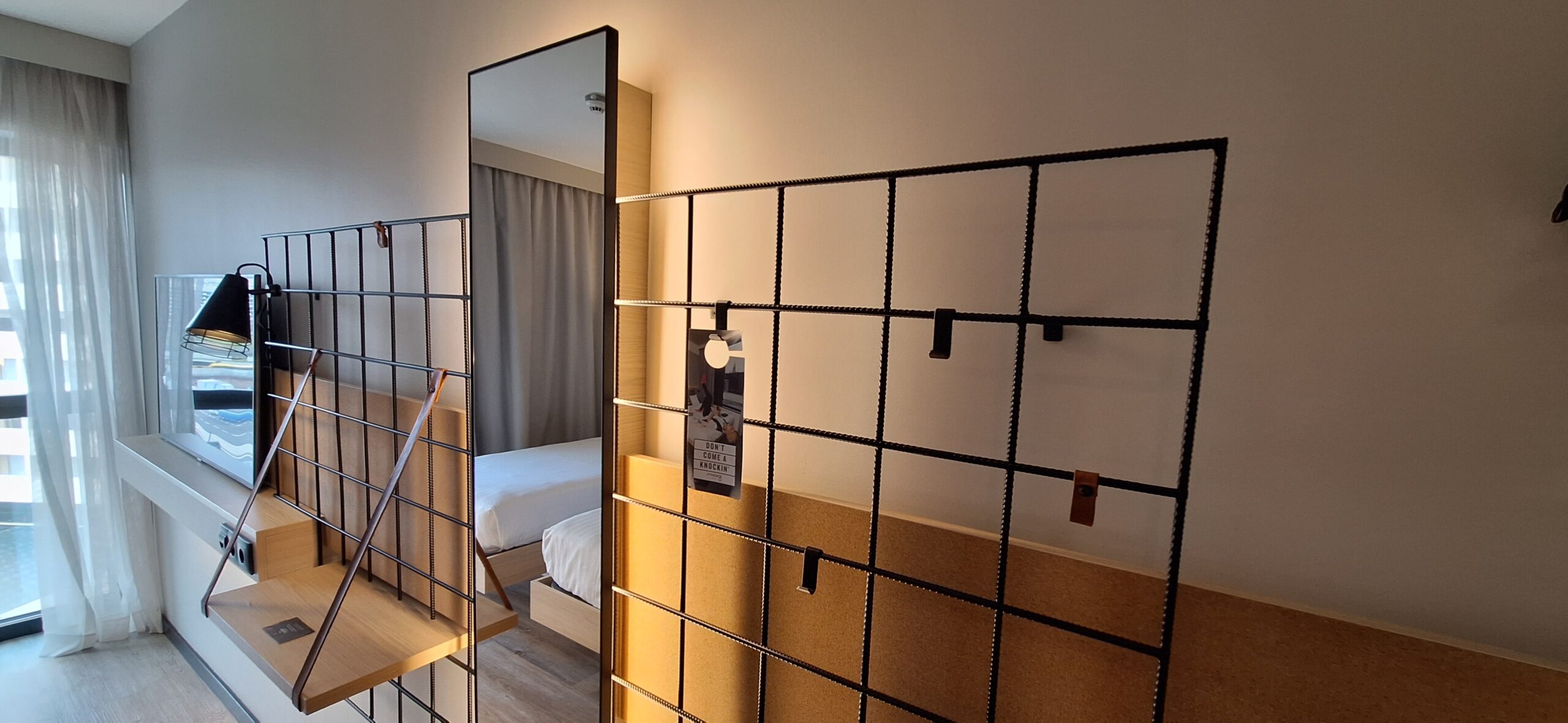 a room with a mirror and a bed