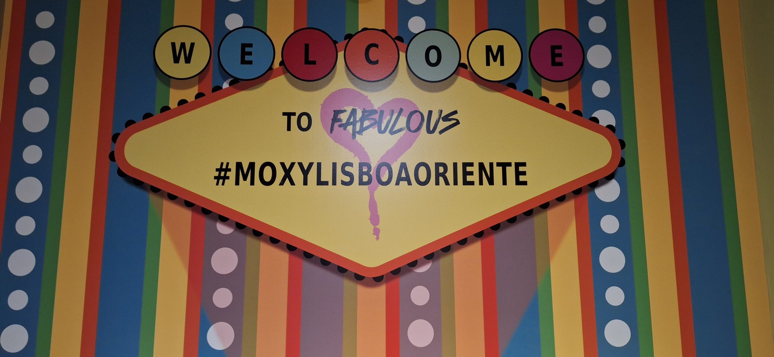 a sign with colorful letters and a heart on it