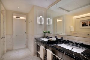Ritz-Carlton Amman Review a bathroom with a large mirror and a black countertop