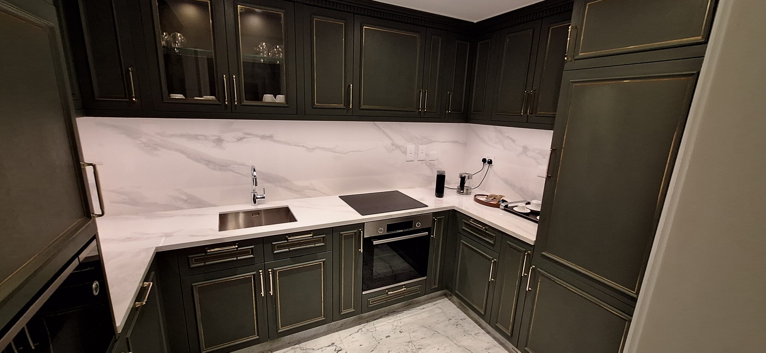 a kitchen with black cabinets and white countertops
