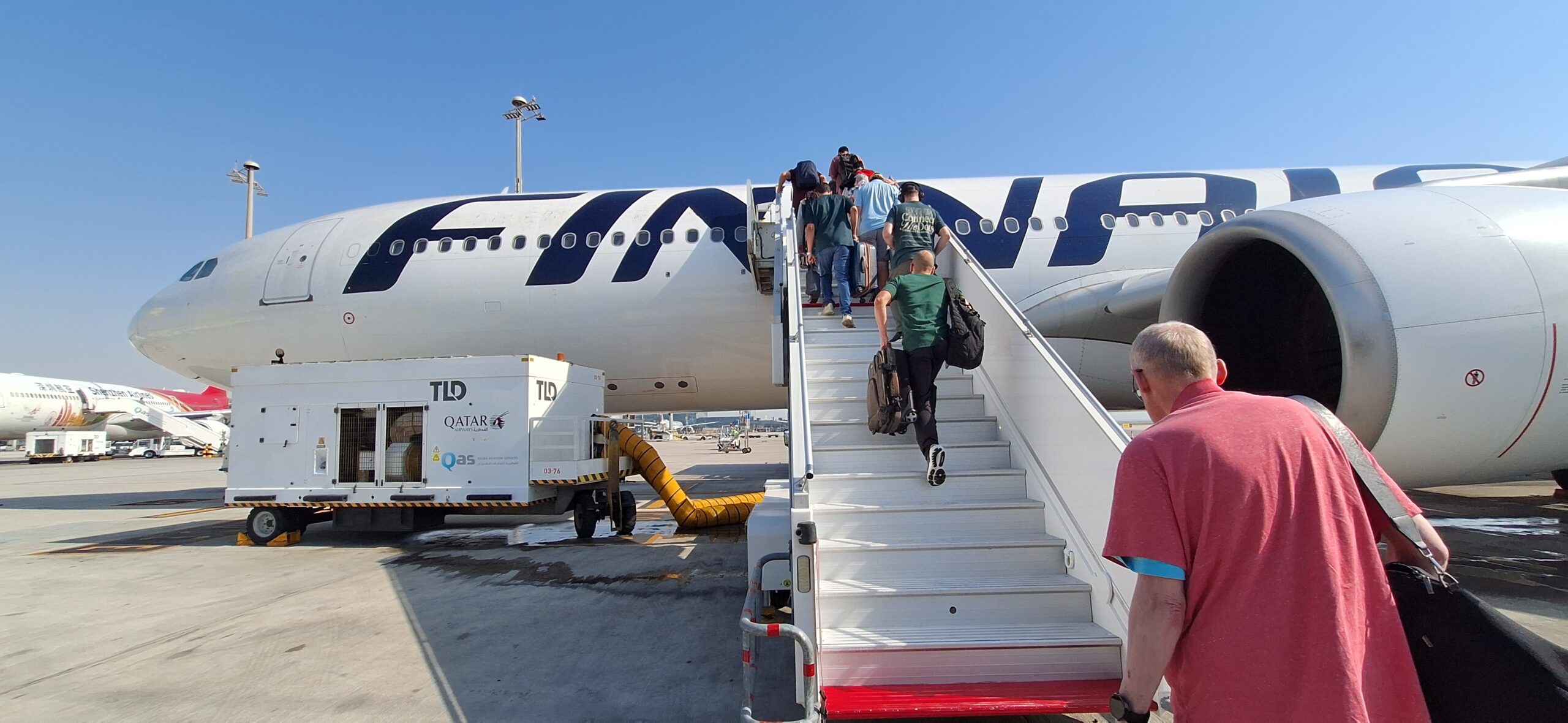 people walking up the stairs of an airplane