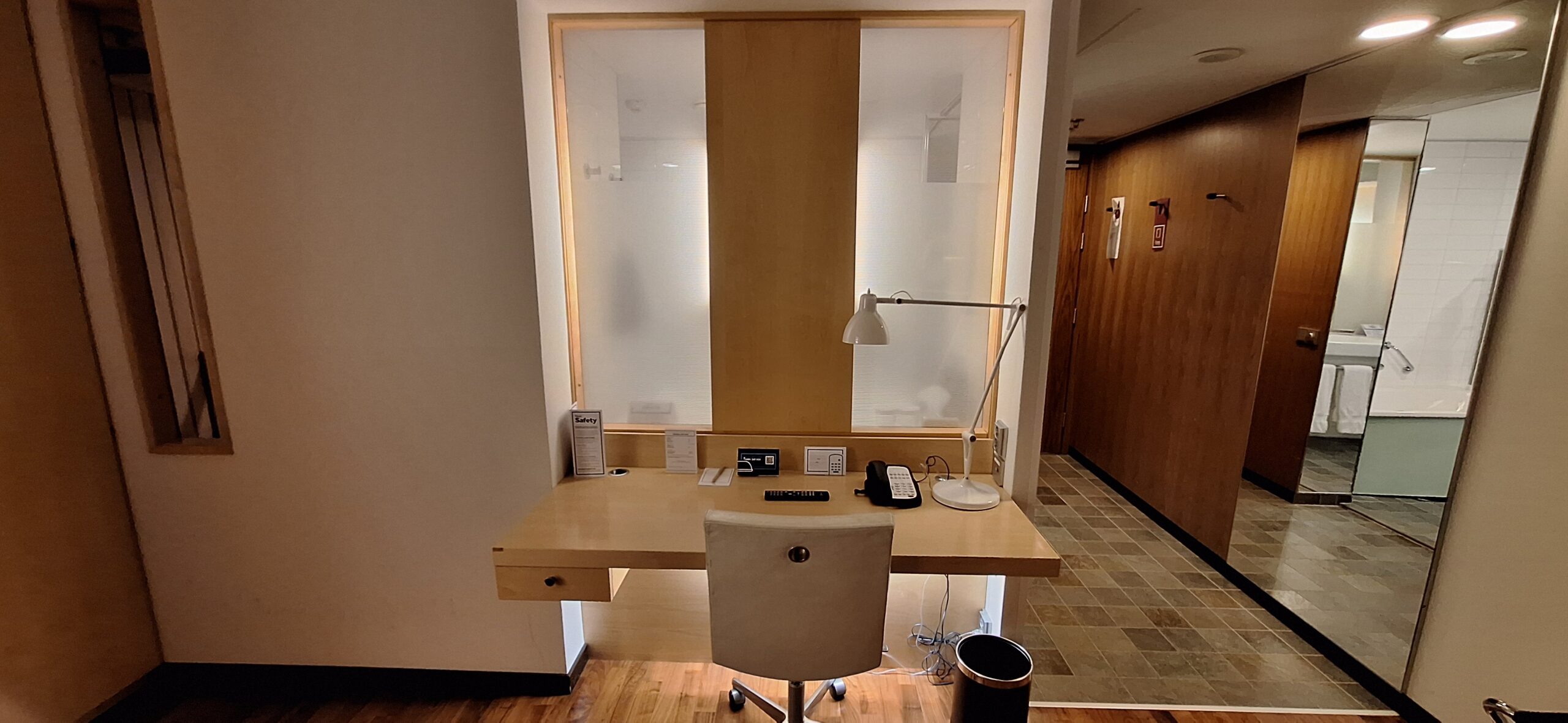 a desk with a lamp and a chair