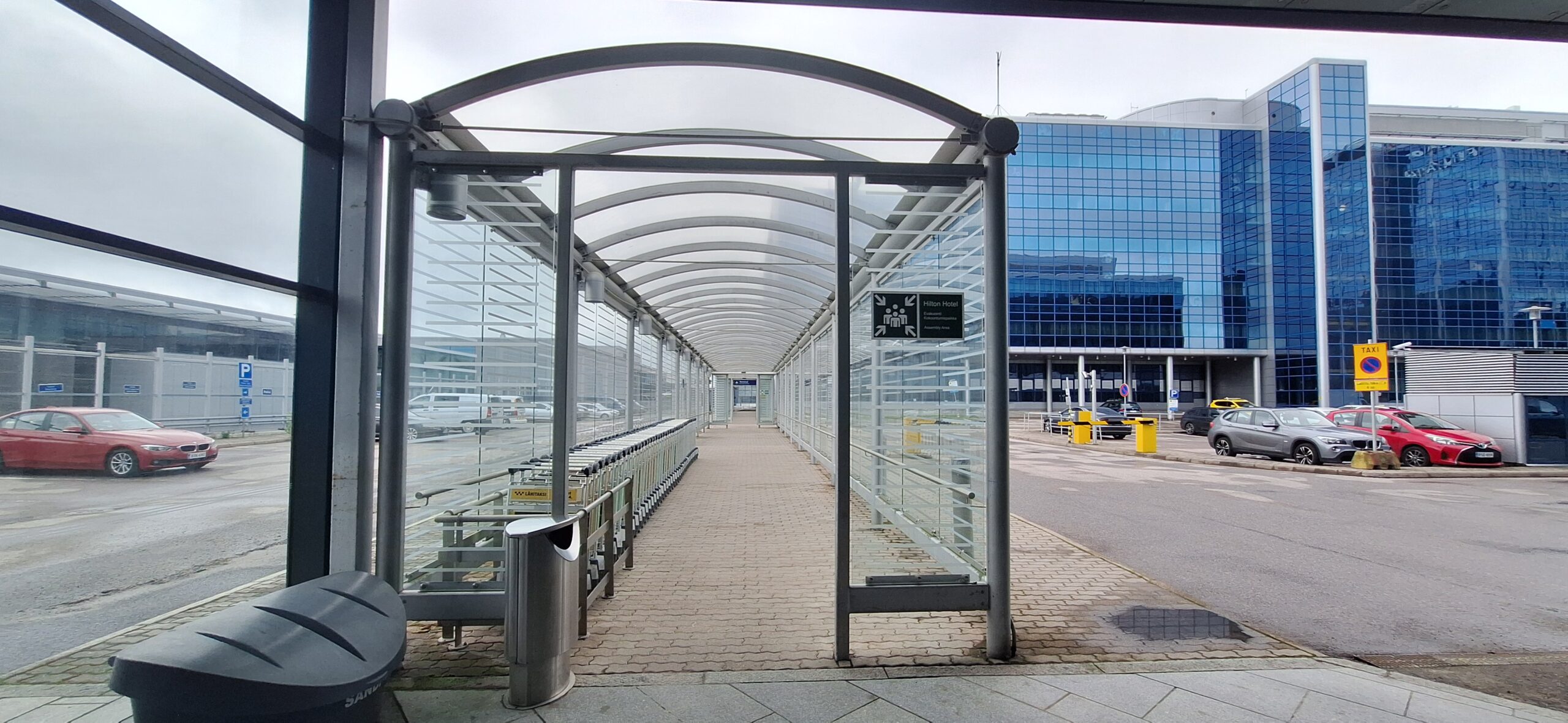 a bus stop with a glass covered walkway